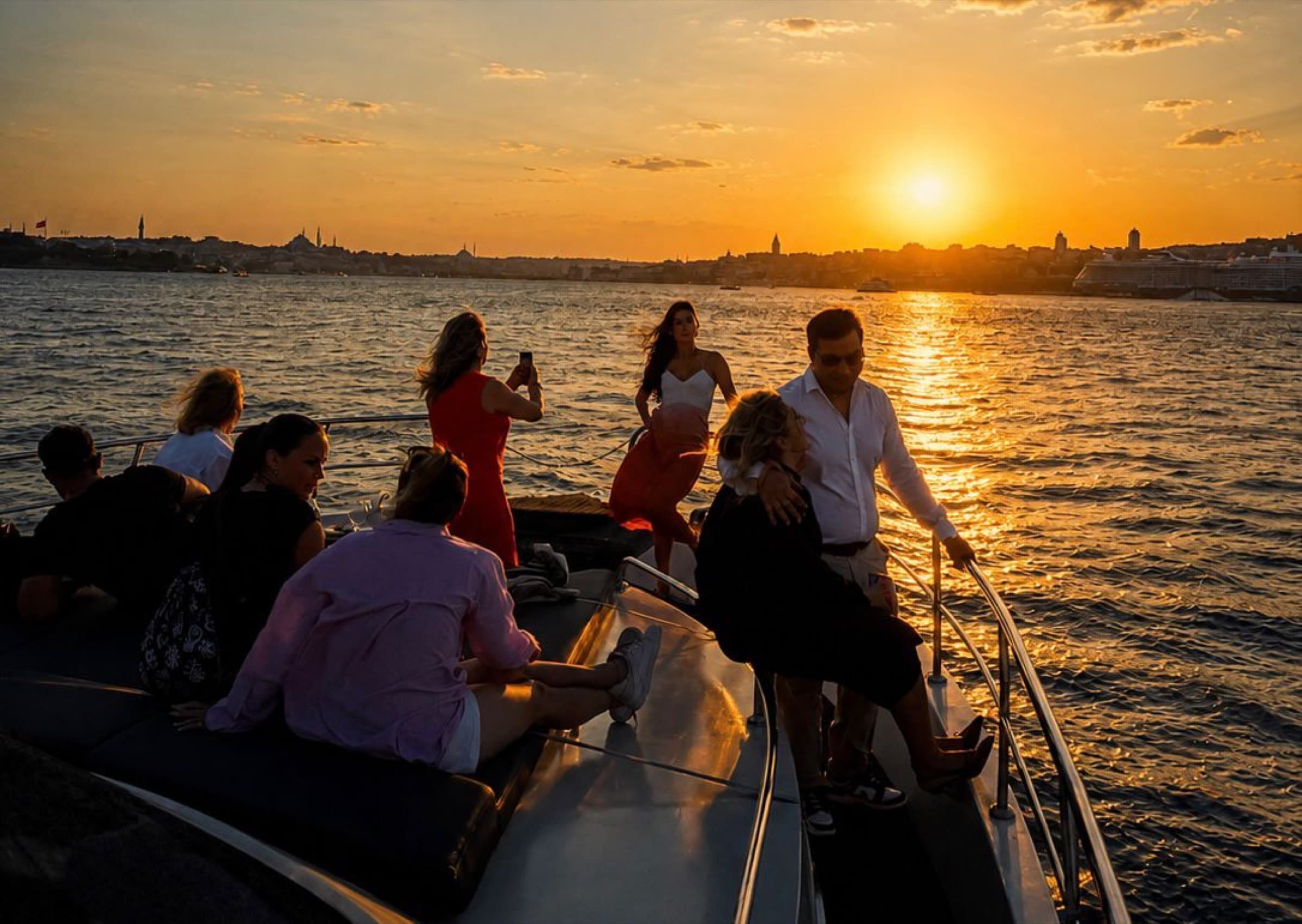 Guests watching the sun set behind the old city from the foredeck