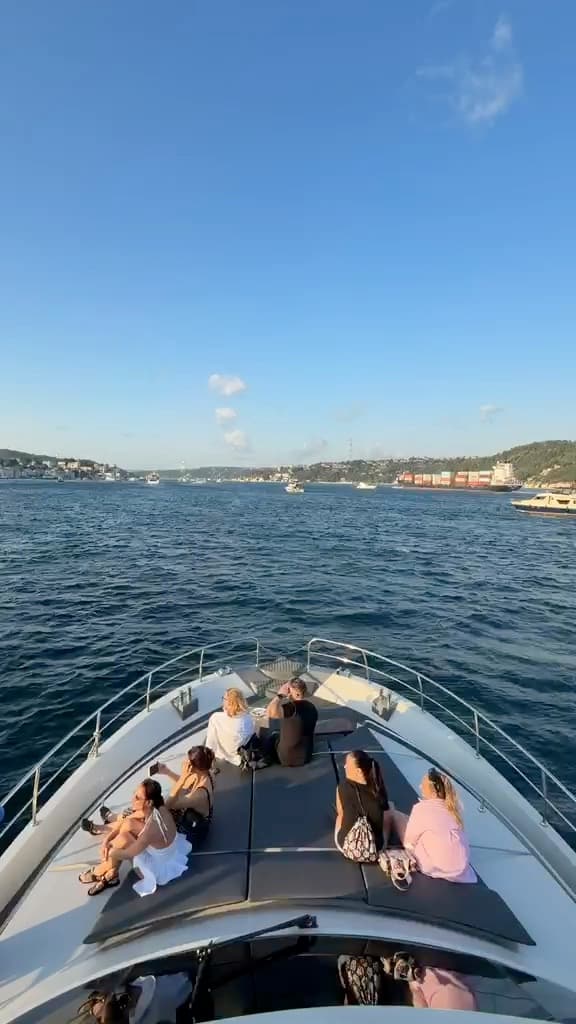 Guests seated on the bow watching the sunset over the Bosphorus