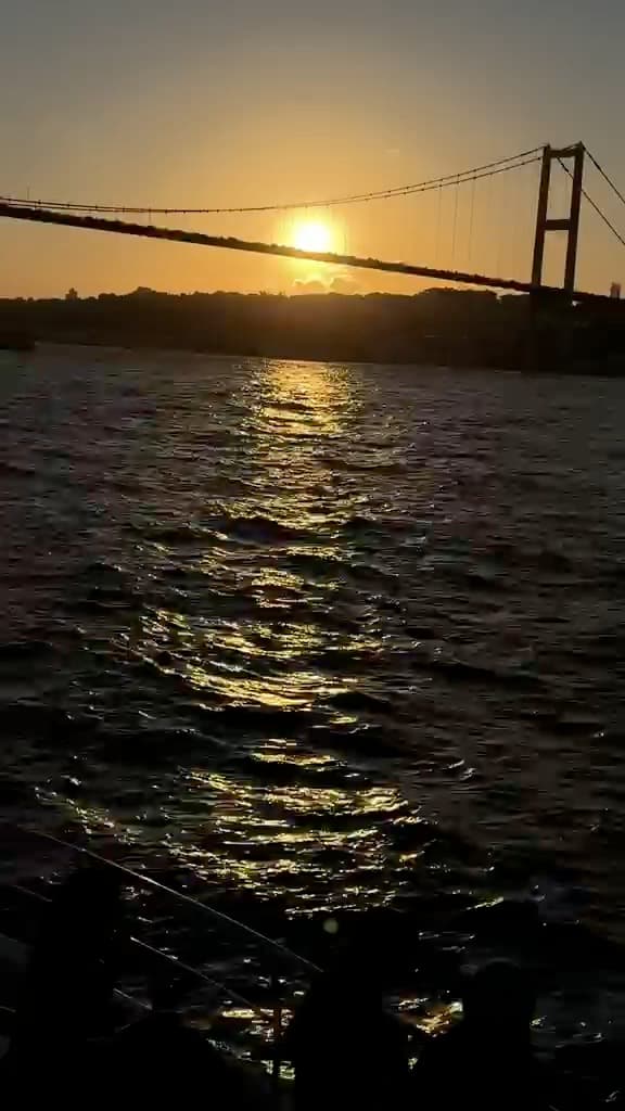 Group dancing on the bow as the sun sets behind the Bosphorus Bridge