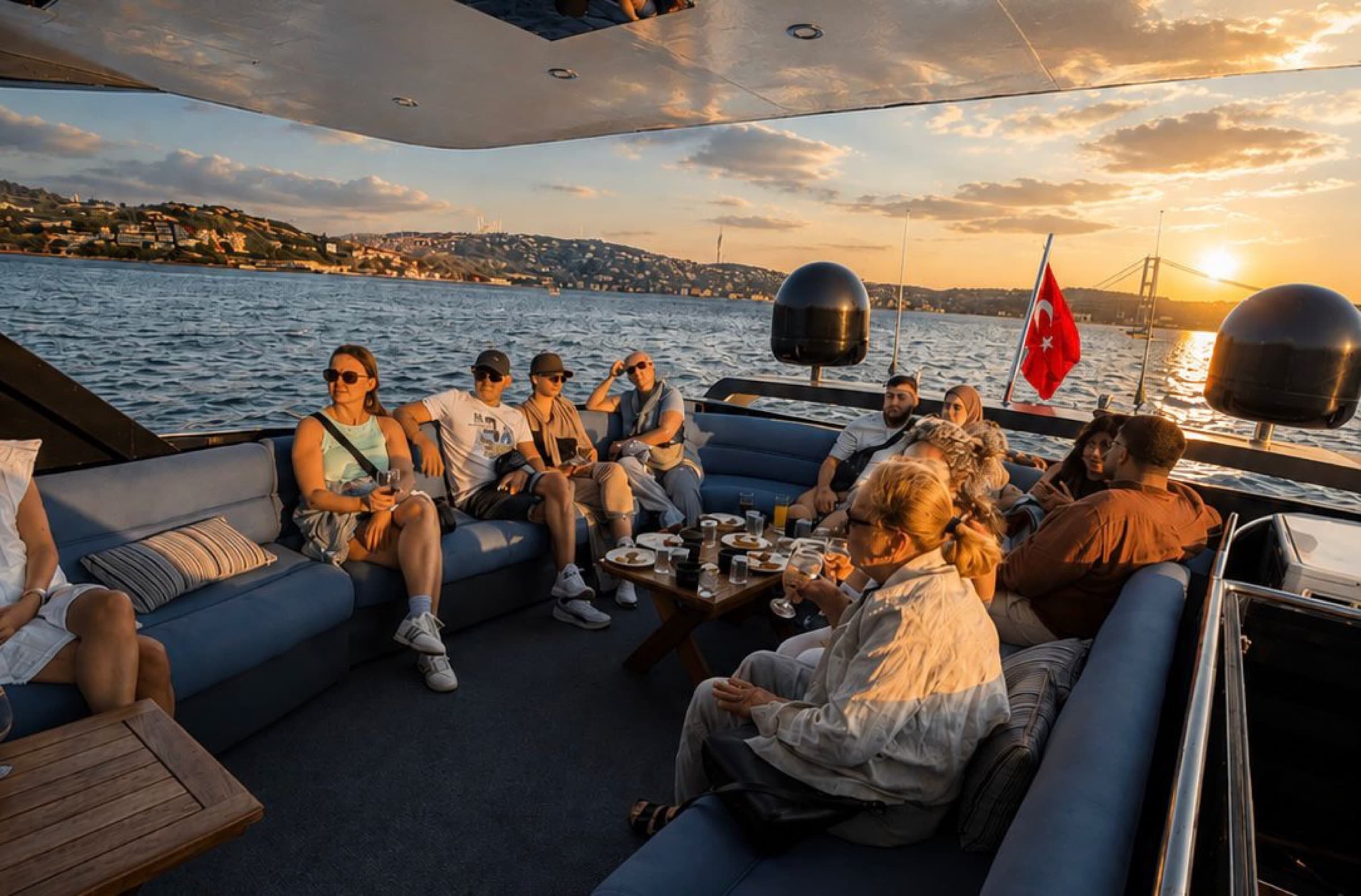 Private group at the upper-deck lounge at sunset, Turkish flag astern