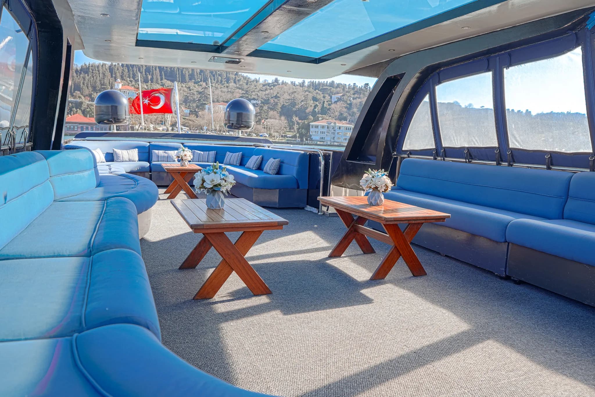 Open upper deck seating with tables, daytime Bosphorus view