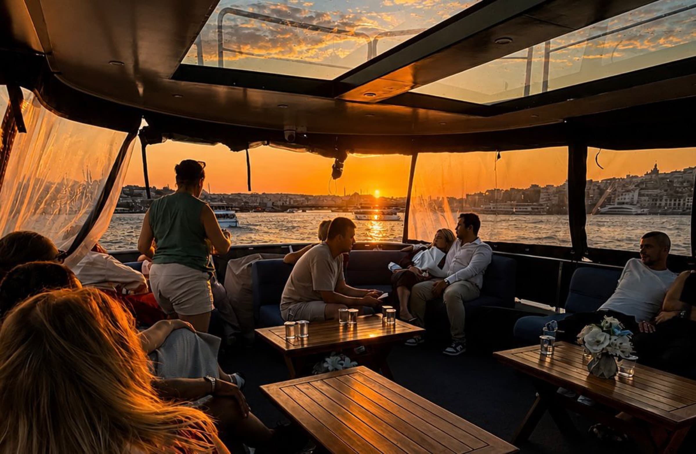 Saloon at sunset with panoramic windows, guests relaxing