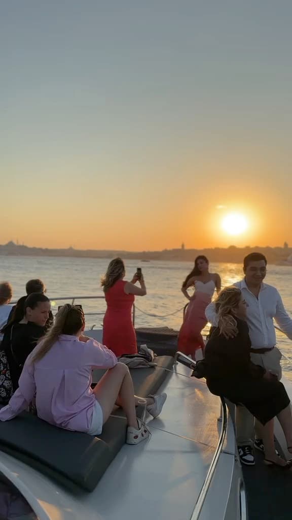 Guests at the bow as the sun sets over the old city
